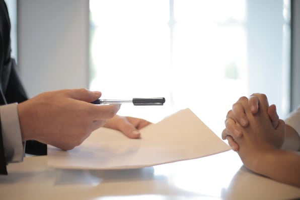 Man offering loan contract and pen to applicant